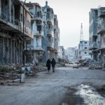 A couple of people walking down at Syria