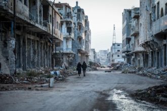 A couple of people walking down at Syria
