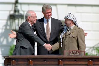 Then-Israeli Prime Minister Yitzhak Rabin shakes hands with PLO leader Yasser Arafat, as U.S. President Bill Clinton looks on. Photo: Archive